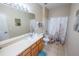 Bright bathroom featuring a large mirror and shower with a patterned shower curtain at 2412 Caravelle Cir, Kissimmee, FL 34746