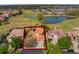 Aerial view of a beautiful home with a well-manicured lawn and mature trees at 2442 Heritage Green Ave, Davenport, FL 33837