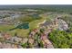 Expansive aerial view showcasing a neighborhood near a golf course with ponds and lush green spaces at 2442 Heritage Green Ave, Davenport, FL 33837