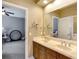 Bathroom featuring a double vanity with a large mirror and a glimpse into the adjoining bedroom at 2442 Heritage Green Ave, Davenport, FL 33837