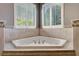 Corner bathtub surrounded by tile, offering a relaxing space with bright, natural light at 2442 Heritage Green Ave, Davenport, FL 33837