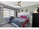 Bedroom with a ceiling fan, large window with blinds, desk, and a bed with colorful decorative pillows at 2442 Heritage Green Ave, Davenport, FL 33837