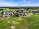 Charming aerial view of a beautiful clubhouse with a golf course, driving range, and putting green at 2442 Heritage Green Ave, Davenport, FL 33837
