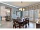 Bright dining room with a dark wood table, decorative light fixture, and access to the backyard at 2442 Heritage Green Ave, Davenport, FL 33837