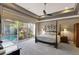 Spacious main bedroom boasts a tray ceiling, ceiling fan, and private access to a pool area at 2442 Heritage Green Ave, Davenport, FL 33837
