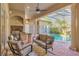 Inviting outdoor living space with comfortable seating and a serene view of the pool and lush landscaping at 2442 Heritage Green Ave, Davenport, FL 33837