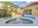 Beautiful screened-in pool area with a tranquil waterfall feature and lush greenery at 2442 Heritage Green Ave, Davenport, FL 33837