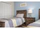 Bedroom showcasing two twin beds, a wood nightstand and a serene blue accent wall at 3185 Pequod Pl, Kissimmee, FL 34746
