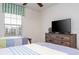 Bedroom featuring two twin beds, ceiling fan, a window, and entertainment center with a television at 3185 Pequod Pl, Kissimmee, FL 34746