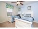 Bedroom featuring twin beds with blue bedding, ceiling fan, and a sunlit window at 3185 Pequod Pl, Kissimmee, FL 34746
