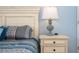 Detail of bedroom nightstand, reading lamp, and decorative bedding with accent pillows at 3185 Pequod Pl, Kissimmee, FL 34746