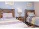 Bedroom with two twin beds, wood nightstand with a lamp, and a serene blue accent wall at 3185 Pequod Pl, Kissimmee, FL 34746