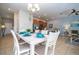 Open-concept dining room with a white table, seating for six, and seamless flow to the kitchen at 3185 Pequod Pl, Kissimmee, FL 34746