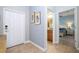 Hallway leading to bathroom and bedroom with tiled floors and neutral walls at 3185 Pequod Pl, Kissimmee, FL 34746