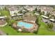 Aerial view of the community pool, surrounded by residences, palm trees, and parking areas at 3301 Whitestone Cir # 204, Kissimmee, FL 34741