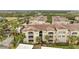 Exterior elevation of multi-story condominiums, with a tile roof, palm trees, and covered parking at 3301 Whitestone Cir # 204, Kissimmee, FL 34741