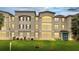 Exterior view of a three-story condo with a beautiful lawn at 3301 Whitestone Cir # 204, Kissimmee, FL 34741