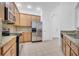 Bright kitchen with stainless steel appliances, granite countertops, tile floor and light wood cabinets at 3301 Whitestone Cir # 204, Kissimmee, FL 34741