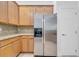 Kitchen featuring stainless steel refrigerator, granite countertops and light wood cabinets at 3301 Whitestone Cir # 204, Kissimmee, FL 34741