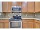 Updated kitchen boasts stainless steel appliances, granite countertops, and light wood cabinetry at 3301 Whitestone Cir # 204, Kissimmee, FL 34741