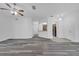 Open-concept living room with gray wood floors and an view of the entry and kitchen at 3301 Whitestone Cir # 204, Kissimmee, FL 34741