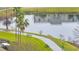 Scenic view of a lakeside walking path with benches and a glimpse of nearby residences at 3301 Whitestone Cir # 204, Kissimmee, FL 34741