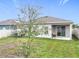 Home featuring backyard with green lawn and covered patio, great for relaxing outdoors at 3493 Lazy River Ter, Sanford, FL 32771