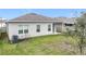 Home featuring backyard with green lawn and covered patio, creating ideal outdoor space at 3493 Lazy River Ter, Sanford, FL 32771