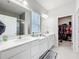 Bright bathroom featuring double sink vanity, quartz counters, tiled floors and walk-in closet at 3493 Lazy River Ter, Sanford, FL 32771