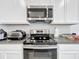 Well-equipped kitchen with stainless steel microwave, range, and granite countertops at 3493 Lazy River Ter, Sanford, FL 32771