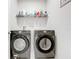 Modern laundry room features front-load washer and dryer with wire shelving above at 3493 Lazy River Ter, Sanford, FL 32771