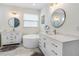 Spa-like bathroom with double vanities, round mirrors, and a modern soaking tub at 350 E 2Nd Ave, New Smyrna Beach, FL 32169