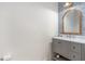 Chic powder room with a gray vanity, mosaic tile backsplash, and a wood-framed mirror at 350 E 2Nd Ave, New Smyrna Beach, FL 32169