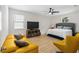 Spacious bedroom with a comfortable bed, yellow sofa and modern ceiling fan at 350 E 2Nd Ave, New Smyrna Beach, FL 32169