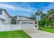 Charming home showcasing a spacious two-car garage, manicured lawn, and modern architectural details at 350 E 2Nd Ave, New Smyrna Beach, FL 32169