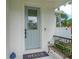 Charming home exterior with a light blue front door, welcome mat, and cozy bench at 350 E 2Nd Ave, New Smyrna Beach, FL 32169