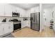 Modern kitchen featuring stainless steel appliances, hardwood floors, and white cabinets at 350 E 2Nd Ave, New Smyrna Beach, FL 32169