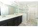 Bright bathroom with a double sink vanity, glass shower, and tile floors, creating a spa-like experience at 3557 Brighton Park Cir, Orlando, FL 32812