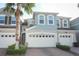 Inviting two-story home featuring a paver driveway, attached garage, and a mature palm tree in the front yard at 3557 Brighton Park Cir, Orlando, FL 32812