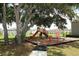 Community playground featuring swings and slides nestled beneath the shade of mature trees at 3557 Brighton Park Cir, Orlando, FL 32812