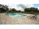 Sparkling community pool with lounge chairs and a serene atmosphere surrounded by lush trees at 3557 Brighton Park Cir, Orlando, FL 32812