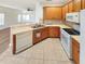 Well-lit kitchen featuring wooden cabinets, white appliances, tile backsplash, and a breakfast bar overlooking the living room at 3745 Clubside Pointe Dr, Orlando, FL 32810