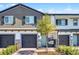 Townhome with a brick driveway, two-car garage, cozy porch swing, and manicured landscaping at 385 Cape Honeysuckle Pl, Sanford, FL 32771