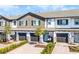 Charming townhome exterior with a brick driveway, attached garage, and a welcoming front porch swing at 385 Cape Honeysuckle Pl, Sanford, FL 32771