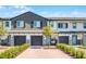 Modern townhome exterior featuring a brick driveway, a two-car garage, and a charming porch swing at 385 Cape Honeysuckle Pl, Sanford, FL 32771
