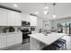 Modern kitchen features an island with seating, stainless steel appliances, and white cabinets at 385 Cape Honeysuckle Pl, Sanford, FL 32771