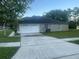 Single-story home with a two-car garage, wide driveway, and well-manicured lawn at 4151 Forest Island Dr, Orlando, FL 32826