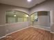 Living room with arched entries, wood floors, and view of the kitchen at 4151 Forest Island Dr, Orlando, FL 32826