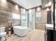 Bright bathroom featuring a modern tub, separate glass shower, and elegant wood-like tiling at 4251 King Edward Dr, Orlando, FL 32826