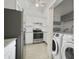 Functional kitchen featuring white cabinets, a stainless steel oven, and a laundry area at 4300 Hector Ct # 7, Orlando, FL 32822